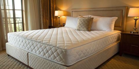 A memory foam mattress with its smooth, contouring surface on a bed in a cozy bedroom.