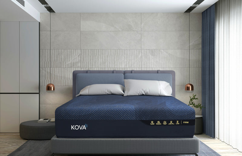 Black KOVA mattress in a bedroom setting with gray walls and decor.