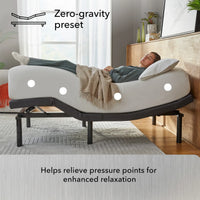 Person lying on a adjustable bed with 'Zero-gravity preset' feature in a bedroom setting.