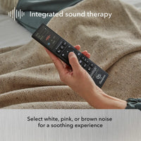 Hand holding a remote control with 'Integrated sound therapy' text and options for white, pink, or brown noise.