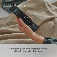 Hand holding a massage remote control with text about a whisper-quiet, dual massage setting.